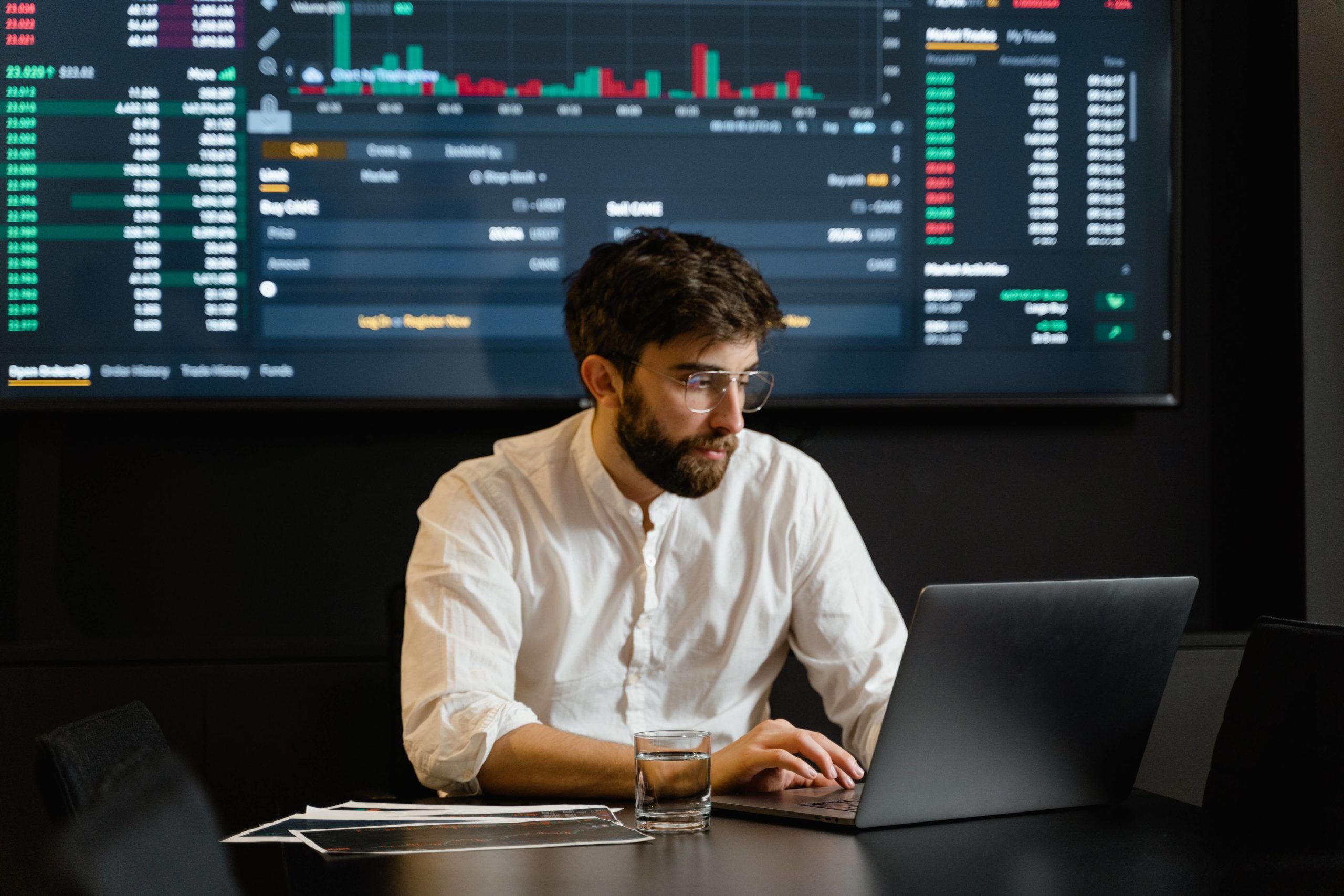 Professional trader analyzing market data on multiple screens in a modern trading environment